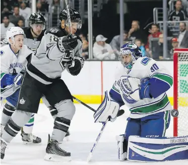  ??  ?? Los Angeles right wing Jarome Iginla, centre, watches the puck deflect off Vancouver goalie Ryan Miller as Vancouver defenceman Troy Stecher, left, and Los Angeles centre Anze Kopitar, second left, look on.