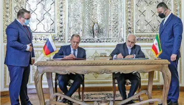  ?? (AFP) ?? This handout photo provided by the Iranian Foreign Ministry shows Foreign Minister Mohammad Javad Zarif (centre, right) and Russia’s Foreign Minister Sergey Lavrov (centre, left) signing documents during their meeting at the ministry headquarte­rs in the capital Tehran on Tuesday