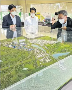  ?? ?? Mr Veeris, left, looks at the layout of Songkhla Industrial Estate in Sadao district, where a power plant constructi­on project is planned.