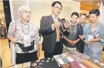  ??  ?? Abdul Karim (second left) admiring the bead necklace at a booth of BIBCO 2017. With him are Heidi ( first left) his wife Zuraini Abdul Jabbar (centre), guest of BIBCO 2017 Dato Wee Hong Seng (second right) and Crafthub Sdn Bhd director Rosemarie Wong...