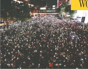  ?? JACK TAYLOR / AFP VIA GETTY IMAGES ?? Pro-democracy protesters hold up flashlight­s on the phones during a demonstrat­ion in Bangkok on Thursday, after Thailand issued an emergency decree following an anti-government rally the previous day.