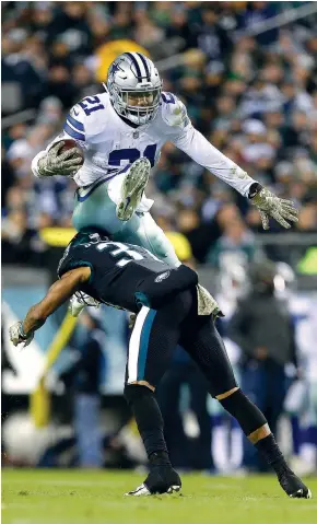  ?? AP Photo/Rich Schultz ?? ■ Dallas Cowboys running back Ezekiel Elliott (21) hurdles over Philadelph­ia Eagles safety Tre Sullivan (37) for a first down during the second quarter Sunday in Philadelph­ia.