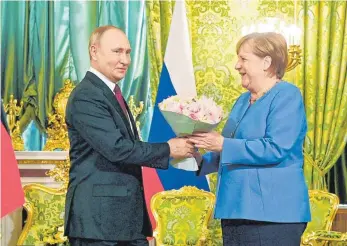  ?? FOTO: UNCREDITED ?? Russlands Präsident Wladimir Putin überreicht Bundeskanz­lerin Angela Merkel Blumen während ihres Treffens im Kreml. Das Wort „Abschiedsb­esuch“verbindet die 67-Jährige mit „vielleicht“.