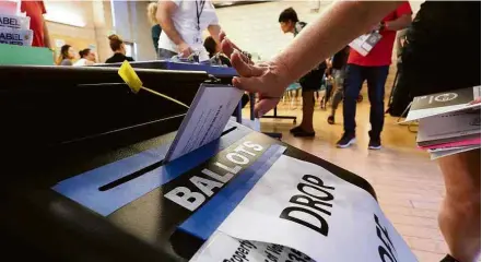  ?? Robyn Beck/AFP ?? Eleitora vota em biblioteca em Los Angeles; processo é antecipado em alguns distritos