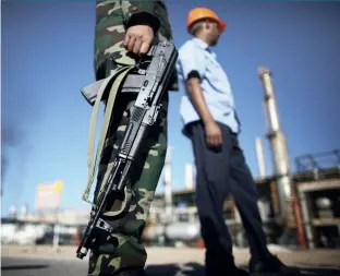  ??  ?? Above: In Libya, a fighter guards an oil refinery. Armed conflict has impacted strongly on the country’s oil production.