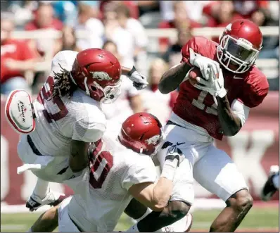  ?? Arkansas Democrat-gazette/william MOORE ?? Arkansas receiver Cobi Hamilton (right) is tackled by Alan Turner (27) and Houston Pruitt after a catch during Saturday’s Red-white game at Reynolds Razorback Stadium in Fayettevil­le. The Red team won the annual scrimmage 65-0.