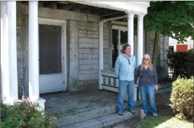  ?? The Associated Press ?? Brian and Joan Dumoulin pose on both sides of a marker showing the U.S.-Canadian border in the front yard of their home. She is in Canada, while he is in the United States.