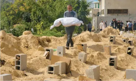  ?? HATEM MOUSSA/AP ?? Palestinia­ns bury the bodies of their relatives killed in the Israeli bombardmen­t of the Gaza Strip at a cemetery in Deir Al-balah on Oct. 23.