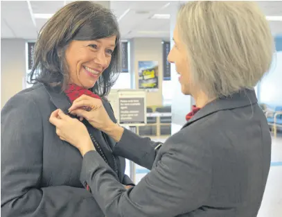  ?? NICOLE SULLIVAN • CAPE BRETON POST ?? Clare MacDougall pins the 35-year service pin on Leslie MacArthur’s jacket. The two women started at Air Canada Jazz on the same day May 15, 1989, and are retiring on the same day 35 years later.