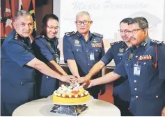  ??  ?? Hamdan (centre), flanked by Edwin (second right) and Khiruddin, leads the cutting of ‘pulut kuning’ (yellow glutinous rice) prior to the meeting.