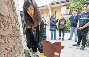  ?? Photograph­s by Irfan Khan
Los Angeles Times ?? MICHELLE OH leaves flowers at the doorstep of the Lins’ home. William Lin, 16, was a junior at Arcadia High School, and younger brother Anthony, 15, was a freshman.