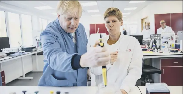  ?? PICTURE: JACK HILL/THE TIMES/PA ?? TESTING TIMES: Mr Johnson at a Bedfordshi­re factory where scientists are working on a way to diagnose coronaviru­s. It is hoped that a vaccine will be ready in about a year.