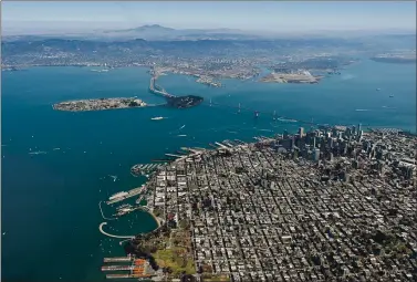  ?? JOSH EDELSON — AFP VIA GETTY IMAGES ?? The Bay Bridge is seen from above in San Francisco in 2015. More mud and dirt will be required to build up the height of marshes and mudflats that ring the bay’s shoreline to combat rising sea levels.