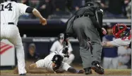  ?? Kathy Willens ?? New York Yankees first baseman Neil Walker (14) watches as Gleyber Torres evades the tag by Boston Red Sox catcher Christian Vazquez to score on Brett Gardner’s two-run triple during the eighth inning in New York on Wednesday.
The Associated Press