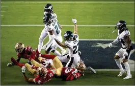  ?? EZRA SHAW/GETTY IMAGES ?? The Philadelph­ia Eagles celebrate after a failed pass in the end zone to end their game against the San Francisco 49ers on Sunday at Levi's Stadium in Santa Clara.