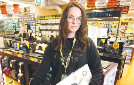  ??  ?? Ella Fleck at JB Hi-fi Brisbane Central store. The company is enjoying surge in sales.
Picture: STEVE POHLNER