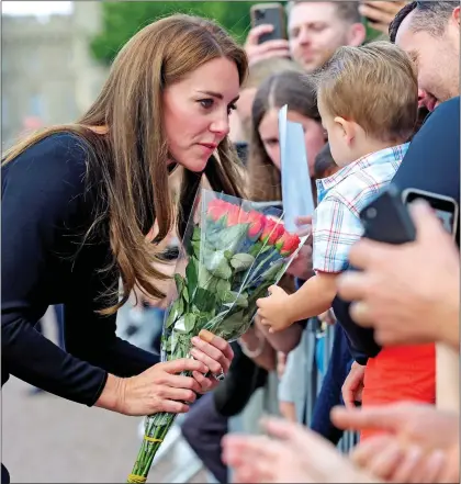  ?? ?? FLOWERS FOR GRANNY: Holding a spray of blooms, Kate chats to a little boy in the crowd outside Windsor Castle