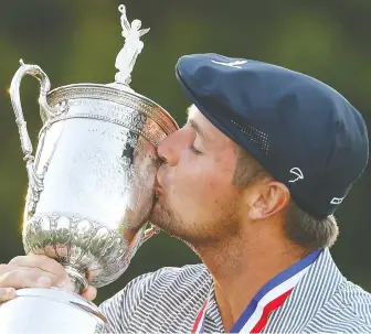  ?? GREGORY SHAMUS/GETTY IMAGES ?? Bryson DeChambeau kisses the championsh­ip trophy in celebratio­n after winning the U.S. Open on Sunday at Winged Foot Golf Club in Mamaroneck, N.Y.