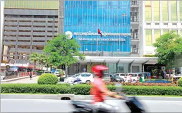  ?? HONG MENEA ?? A man rides a motorcycle past the headquarte­rs of the National Election Committee (NEC).