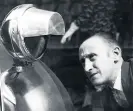  ??  ?? A motorist inspects a blackout hood on his car headlights, in Cardiff, 1939