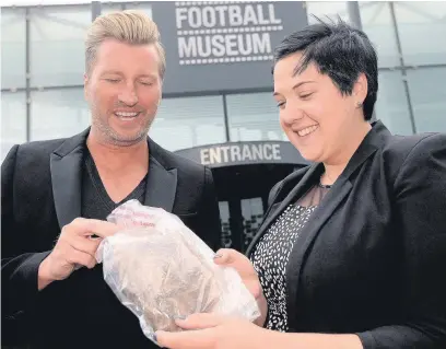  ??  ?? ●● Ex footballer Robbie Savage hands over his hair to Sally Hawley