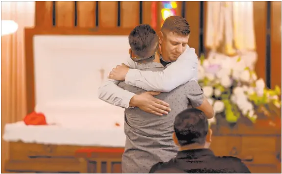  ?? K.M. Cannon Las Vegas Review-journal @Kmcannonph­oto ?? Nicholas Husted, facing, hugs friend Peter Prum of San Jose, Calif., during a funeral service Friday for his son, Liam Husted.