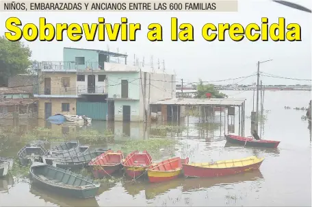  ??  ?? Una niña vuelve de la despensa en canoa. Vive peligrosam­ente con la mitad de su casa inundada en varadero.