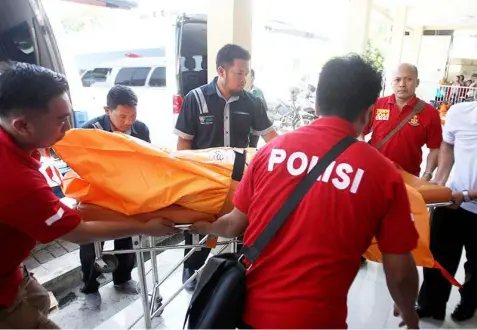  ??  ?? Police officers carry a body bag containing one of the victims of Sunday’s explosions upon arrival at a hospital in Surabaya, East Java, Indonesia, Monday, May 14, 2018. (AP)