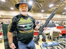  ?? POSTMEDIA ?? A collector holds an SKS rifle at a Calgary gun show on Sept. 21, 2019. The SKS, a precursor to the AK-47, is one of the rifles not covered by the Liberals’ recent ban on “military-style” firearms.