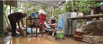  ?? ?? MANGSA banjir, Zainuddin Chambate, 48, mengemas rumahnya di Kampung Pengkalan Pauh, Lubok China, Alor Gajah yang dilanda banjir.