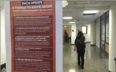  ??  ?? In this photo taken Sept. 7, a student walks past a tip sheet for Deferred Action for Childhood Arrivals recipients who fear deportatio­n that is taped to a window on the University of California, Berkeley campus in Berkeley. AP PHOTO/JOCELYN GECKER