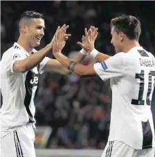  ?? | AP ?? JUVENTUS forward Paulo Dybala, right, celebrates with Cristiano Ronaldo after scoring during the Champions League group H match between Manchester United and Juventus at Old Trafford, in Manchester, last night.