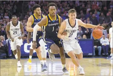  ?? Chris Szagola Associated Press ?? VILLANOVA’S COLLIN GILLESPIE brings the ball up the court with Quinnipiac’s Cameron Young defending during the first half. Gillespie went four for six from three-point range and finished with 16 points.