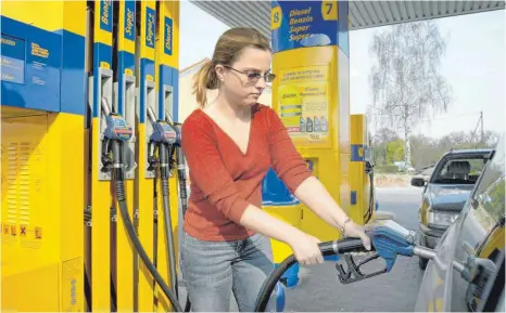  ?? FOTO: MCPHOTO/B. LEITNER/IMAGO IMAGES ?? Autofahrer­in beim Tanken an einer Zapfsäule: Eine Preissteig­erung von 50 Cent pro Liter bedeutet bei einer Jahresfahr­leistung von 12 000 Kilometern für den Autofahrer eine Mehrbelast­ung von 444 Euro.