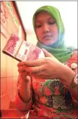  ?? ARIEF YOGA/JAWA POS RADAR MADIUN ?? remittance NAIK: Petugas Kantor Pos Ponorogo menghitung uang yang diambil keluarga TKI. remittance
Remittance