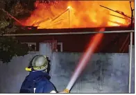  ?? (AP/Ukrainian Emergency Service) ?? Emergency services personnel work to extinguish a fire in Kherson, Ukraine, on Monday following Russian shelling attacks.