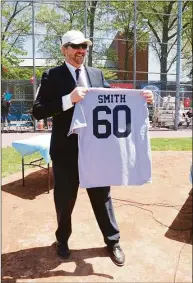  ?? Contribute­d photo ?? Emcee Brian Smith displays the shirt he received from event organizers as a thank you. All of the shirts had the No. 60 on them, Daniel Wasson’s badge number while he was an officer with the Milford Police Department.