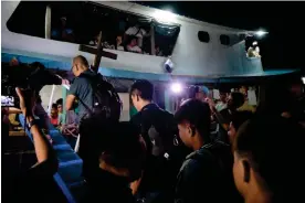  ?? ?? Father Robert Reyes boards the Christmas convoy vessel bearing the Pilgrim Mission Cross. He was part of the group voyaging to the West Philippine Sea to areas that are disputed territory with China. Photograph: Atin Ito coalition