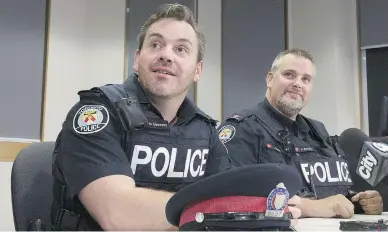  ?? STAN BEHAL / POSTMEDIA NEWS ?? Constables Josh McSweeney and Ryan Barnett swam through the flooded basement to rescue the trapped men.