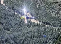  ?? PHOTO: THE NEW ZEALAND HERALD ?? Financial toll . . . A helicopter flies over Pigeon Valley while fighting the Nelson fires yesterday.