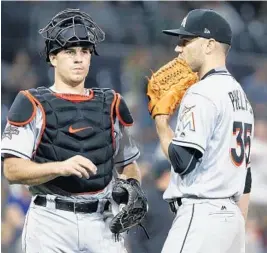 ?? CHRISTINE COTTER/AP ?? Miami’s David Phelps, right, here with J.T. Realmuto on Friday night, had his second straight clean inning Sunday as he tries to come back from a rough start to the season.