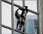  ??  ?? Alain Robert a escaladé à mains nues lundi matin la tour Total à la Défense, à Courbevoie, en signe de soutien à la grève contre la réforme des retraites.