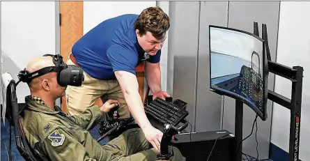  ?? DARYL MAYER / U.S. AIR FORCE ?? Matt Murdock, a Simulators Division contractor, assists Col. Cameron Dadgar, Nevada Test and Training Range commander, during a demonstrat­ion of a virtual reality flight simulator in the new “Sims Holodeck.”