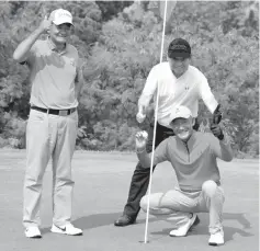  ??  ?? Roger Lo (holding the ball) celebrates his ace with flightmate­s Masahisa Kawakami (left) and Nestor Mendoza on the green of hole No. 6.