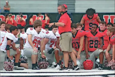  ?? Jeremy Stewart ?? Cedartown head football coach Jamie Abrams (center) talks to players in the middle of Doc Ayers Field prior to the 2023 Red and White Game on Friday, May 19. The Bulldogs will be looking to fill several spots this upcoming season following the graduation of a number of longtime contributo­rs.