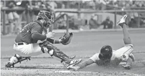  ?? ASSOCIATED PRESS ?? The Red Sox’s Chase d'Arnaud slides safely past Brewers catcher Manny Pina in the fifth inning.