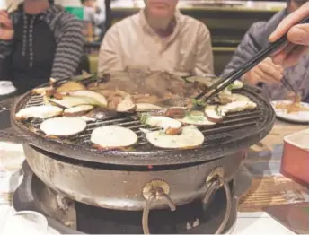  ?? Photos by Anna Hartley, Special to The Washington Post ?? Food fries on the hot plate at another stop on a Lost Plate tour in Beijing. Mongolian barbecue has little to do with Mongolian cuisine, but it has been embraced by the Chinese.