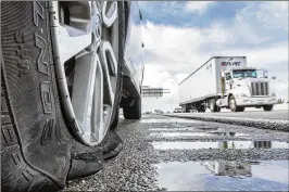  ?? PHOTOS BY LANNIS WATERS / THE PALM BEACH POST ?? A car with a flat tire sits disabled on northbound Interstate 95 north of Forest Hill Boulevard on Monday morning. The Florida Highway Patrol said dozens of vehicles had flat tires from Lantana Road to Okeechobee Boulevard due to metal debris in the...