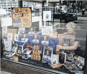  ?? SHAUGHN BUTTS ?? Deborah Hines of Audreys Books on Jasper Avenue adjusts some of the items in an Oilers window display.