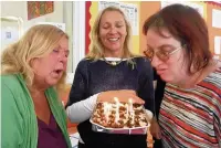  ??  ?? ●● Helen Jones and Jane Naden, blowing out the birthday candles, are original members